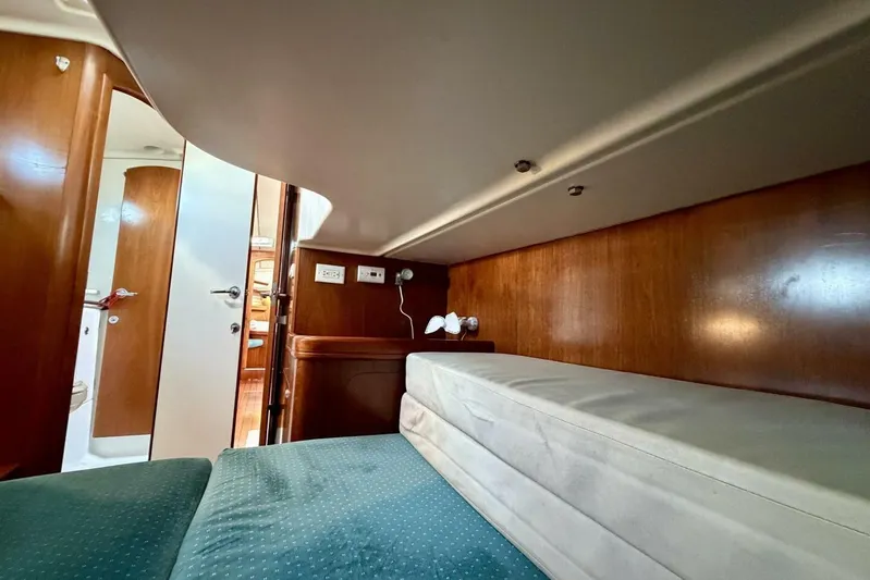 Eda Yacht Photos Pics Interior cabin of 2000 Beneteau Oceanis 461 yacht with wooden finish and cozy bedding.