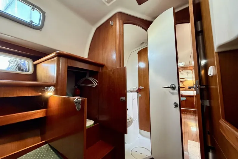 Eda Yacht Photos Pics Interior of 2000 Beneteau Oceanis 461 yacht, featuring wood cabinetry and compact bathroom.