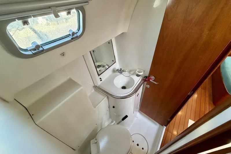 Eda Yacht Photos Pics Beneteau Oceanis 461 yacht bathroom with sink, toilet, and porthole window, 2000 model.