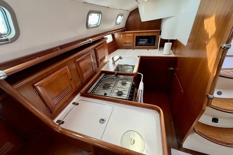 Eda Yacht Photos Pics Interior of 2000 Beneteau Oceanis 461 yacht kitchen with wood cabinetry and appliances.