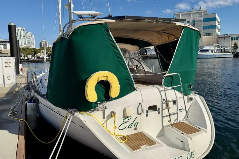 Eda Yacht Photos Pics Beneteau Oceanis 461 sailboat, 2000 model, docked with green canopy and cityscape background.