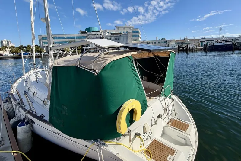 Eda Yacht Photos Pics Beneteau Oceanis 461 sailboat docked at marina, 2000 model, with green canopy.