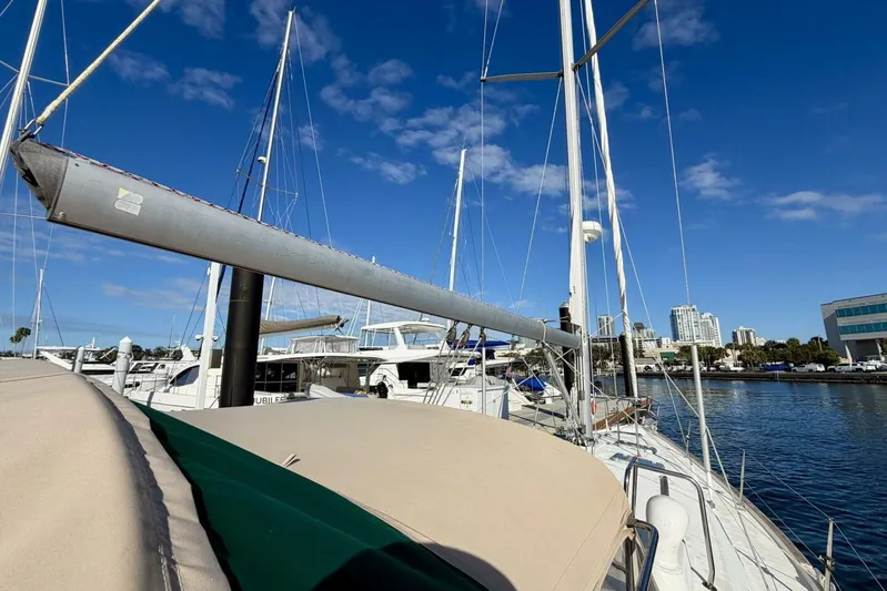 Eda Yacht Photos Pics Beneteau Oceanis 461 sailboat docked at marina, clear blue sky, cityscape background.