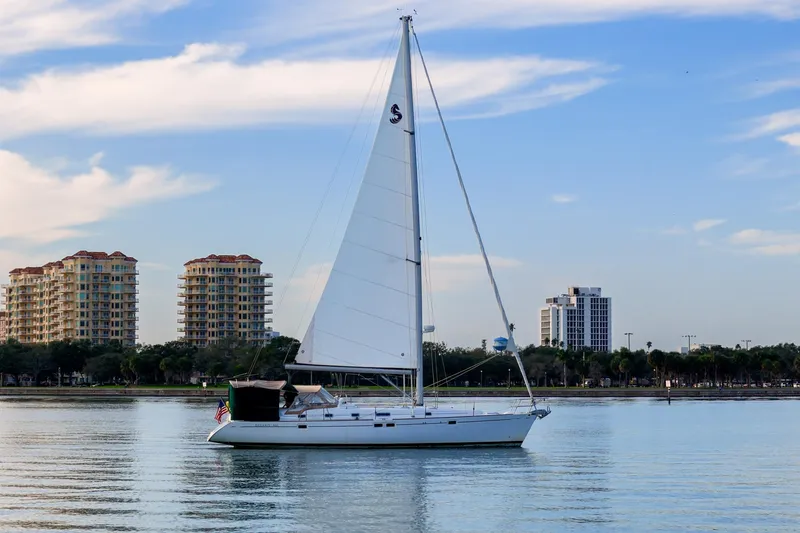 Eda Yacht Photos Pics Sailboat Beneteau Oceanis 461 (2000) on calm water with cityscape background.