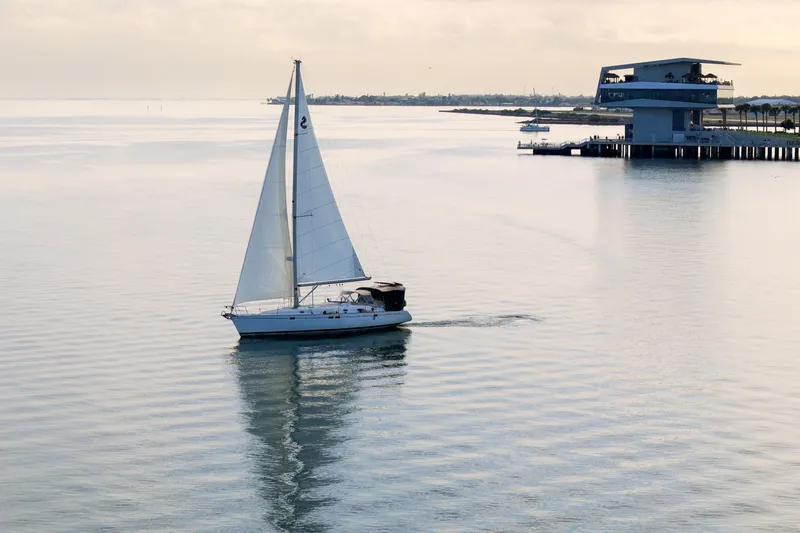 Eda Yacht Photos Pics Sailboat Beneteau Oceanis 461, 2000 model, cruising near modern waterfront structure.