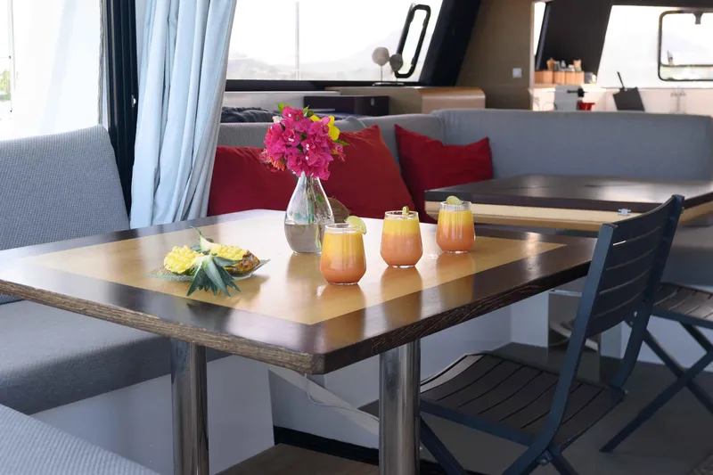  Yacht Photos Pics Interior of NEEL 51 (2017) with table, drinks, flowers, and seating.