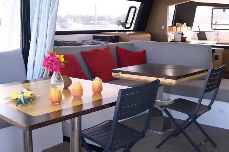  Yacht Photos Pics Interior of 2017 NEEL 51 yacht with dining area, colorful cushions, and fresh drinks.