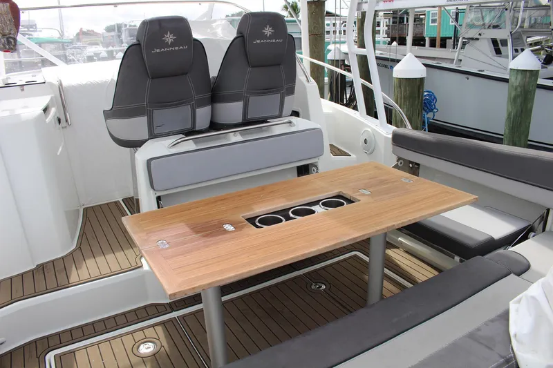  Yacht Photos Pics 2021 Jeanneau Leader 9.0 WA boat interior with seating and wooden table.