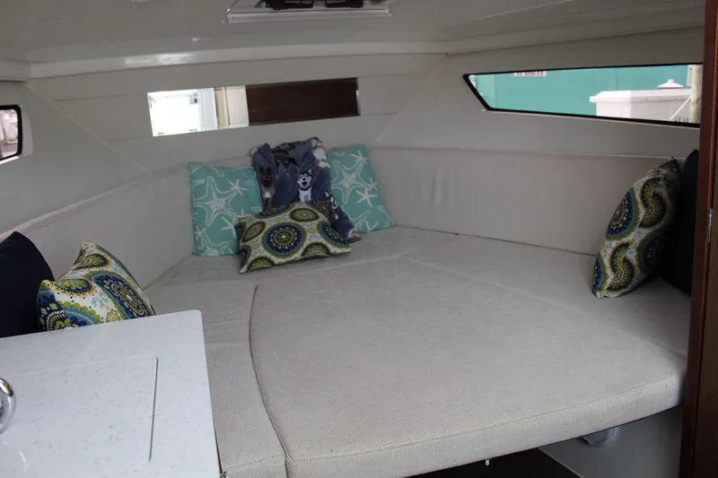  Yacht Photos Pics 2021 Jeanneau Leader 9.0 WA cabin interior with cozy seating and decorative pillows.