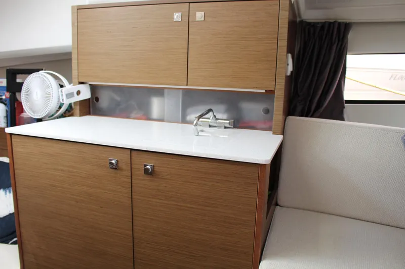  Yacht Photos Pics Interior of 2021 Jeanneau Leader 9.0 WA, featuring a compact kitchenette with wood cabinetry.