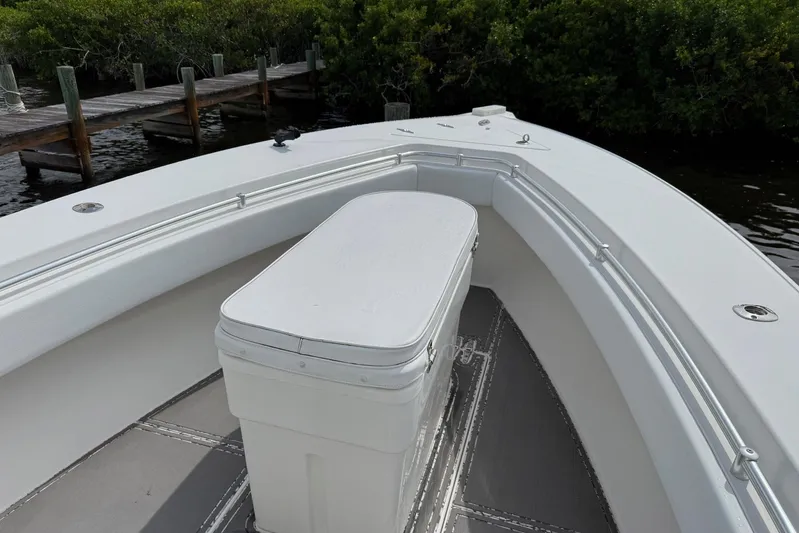  Yacht Photos Pics 2011 Contender 32 ST boat with white seating, docked near lush greenery.