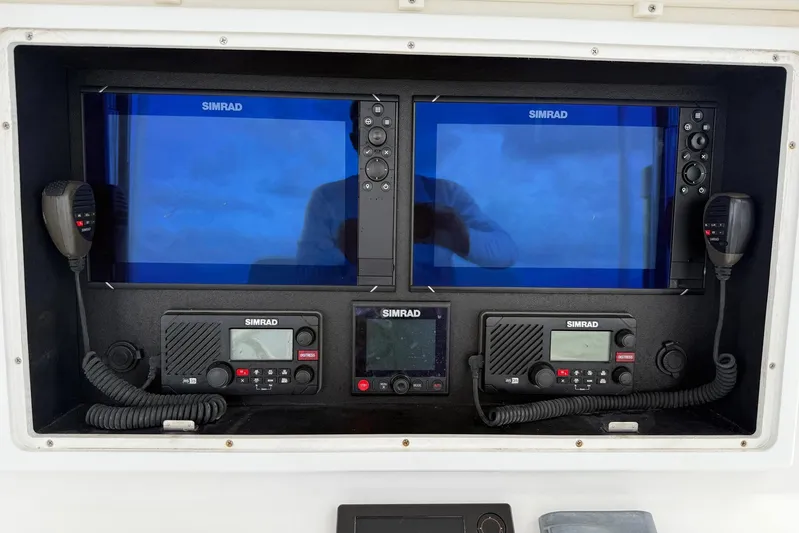  Yacht Photos Pics Simrad marine electronics on 2011 Contender 32 ST boat dashboard, featuring dual displays and communication devices.