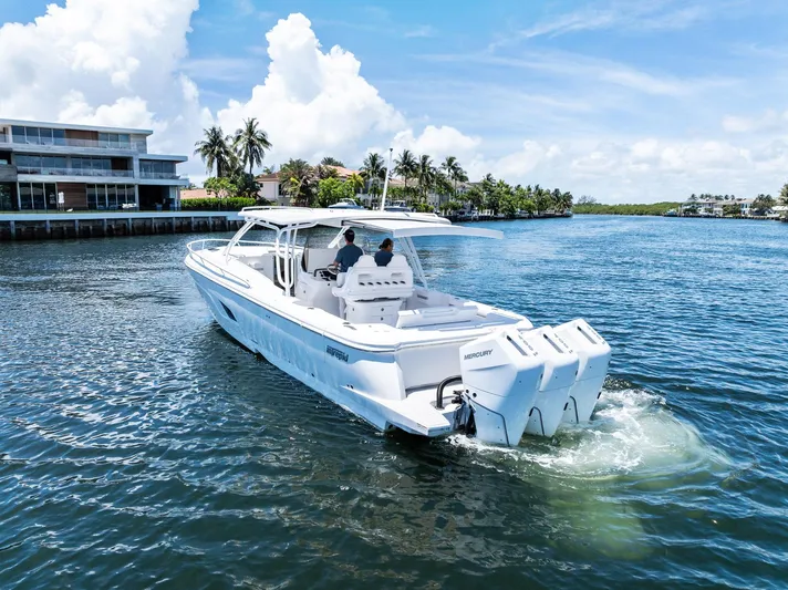  Yacht Photos Pics 2024 Intrepid 41 Valor cruising on a sunny day near waterfront homes.