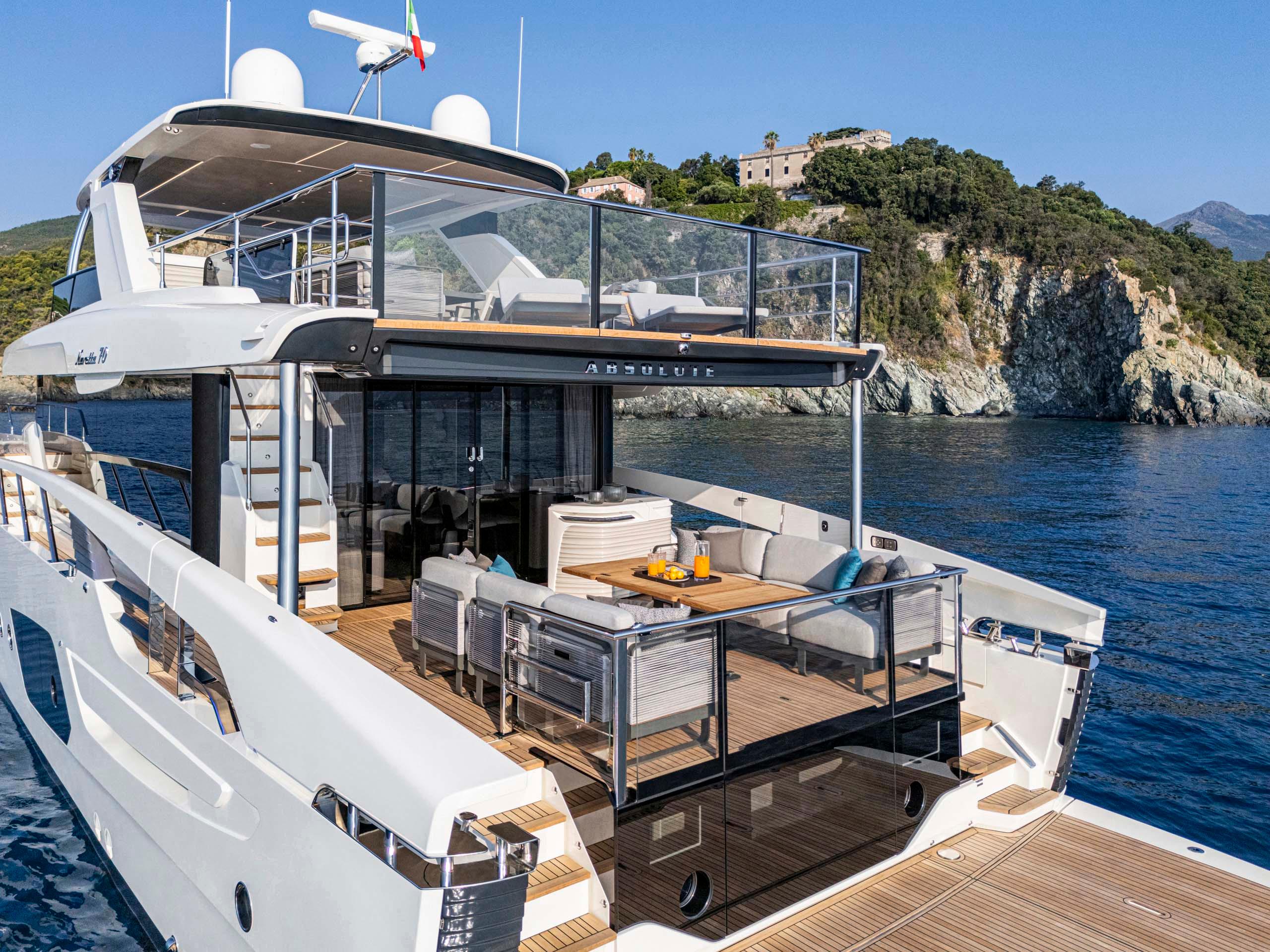 Luxury Absolute 70' Navetta yacht, 2026 model, cruising near scenic rocky coastline.