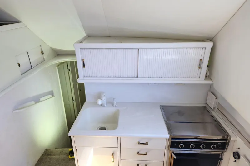 Nobody Yacht Photos Pics 1988 Ocean Yachts 48 Super Sport kitchen with sink, stove, and storage cabinets.