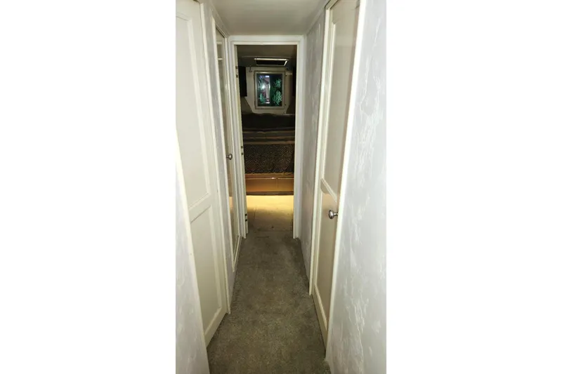 Nobody Yacht Photos Pics Narrow hallway inside 1988 Ocean Yachts 48 Super Sport, featuring white doors and carpet.