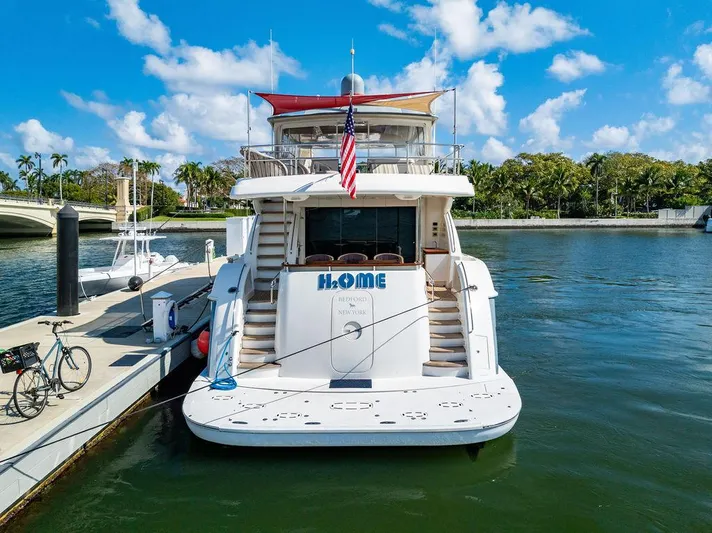  Yacht Photos Pics Hatteras 80 Motor Yacht 2013 docked, rear view with American flag, sunny day.