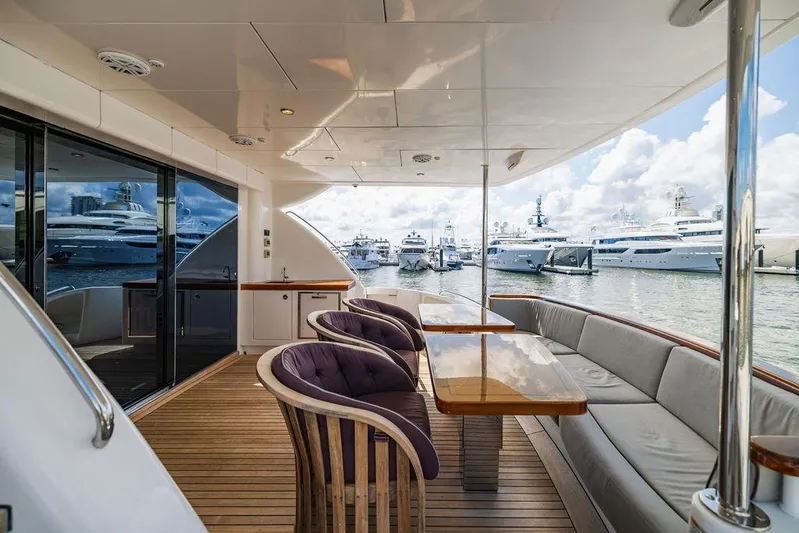  Yacht Photos Pics Luxurious 2013 Hatteras 80 Motor Yacht deck with elegant seating and marina view.