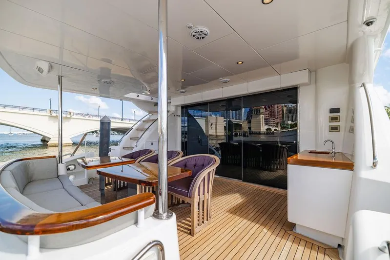  Yacht Photos Pics 2013 Hatteras 80 Motor Yacht deck with seating, table, and waterfront view.