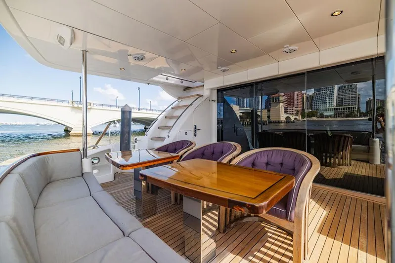  Yacht Photos Pics Luxury deck of 2013 Hatteras 80 Motor Yacht with elegant seating and wooden table.