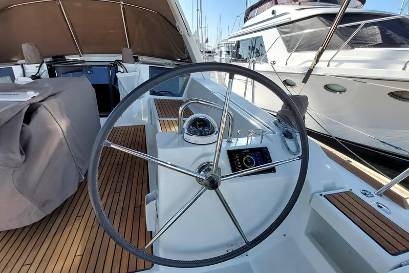 La Bella Vita Yacht Photos Pics Steering wheel of 2015 Beneteau Oceanis 45 yacht with wooden deck and navigation instruments.
