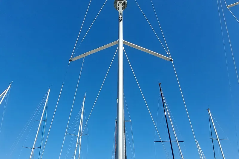 La Bella Vita Yacht Photos Pics Masts of Beneteau Oceanis 45 sailboats against a clear blue sky.
