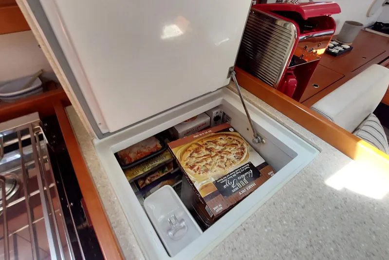La Bella Vita Yacht Photos Pics Freezer compartment on 2015 Beneteau Oceanis 45 yacht with frozen meals and pizza.