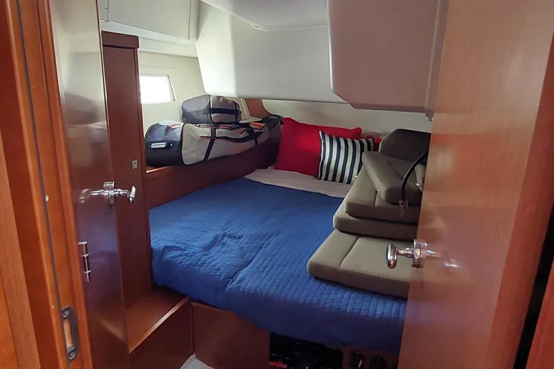 La Bella Vita Yacht Photos Pics Cozy cabin interior of 2015 Beneteau Oceanis 45 with blue bedding and luggage.