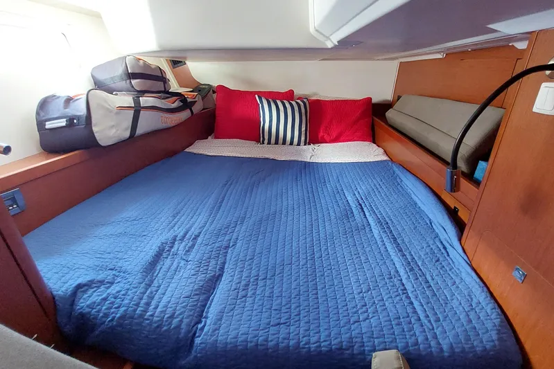 La Bella Vita Yacht Photos Pics Cozy cabin interior of 2015 Beneteau Oceanis 45 with blue bedding and red pillows.