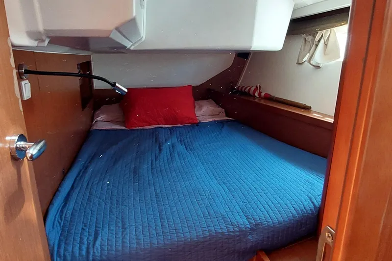 La Bella Vita Yacht Photos Pics Cozy cabin interior of 2015 Beneteau Oceanis 45 with blue bedding and red pillow.