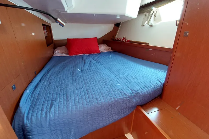 La Bella Vita Yacht Photos Pics Cozy cabin interior of 2015 Beneteau Oceanis 45 with blue bedding and red pillow.