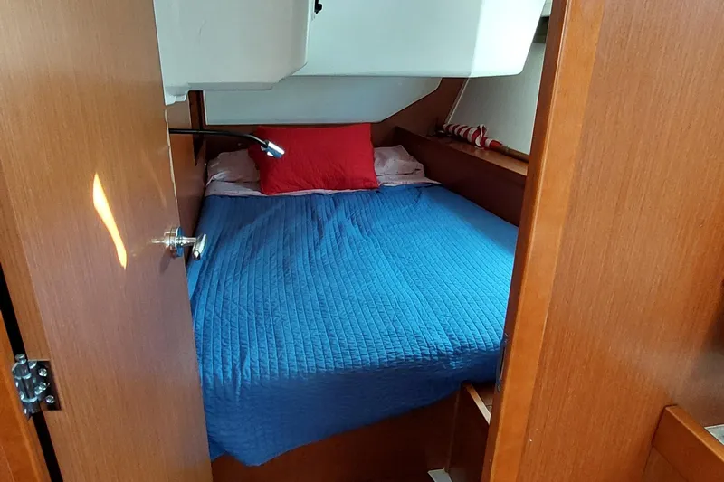 La Bella Vita Yacht Photos Pics Cozy cabin interior of 2015 Beneteau Oceanis 45 with blue bedding and red pillow.