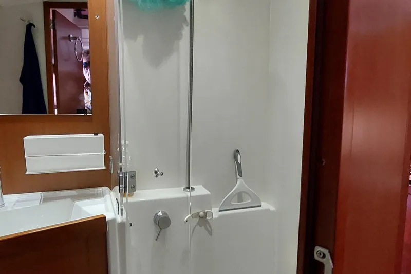 La Bella Vita Yacht Photos Pics Bathroom interior of 2015 Beneteau Oceanis 45 yacht, featuring shower and wooden accents.