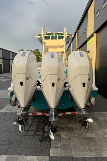  Yacht Photos Pics 2020 Onslow Bay 33 Tournament boat with triple outboard engines, docked on a paved surface.