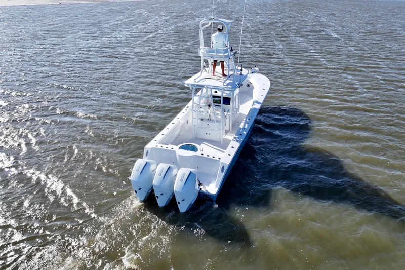  Yacht Photos Pics 2021 Onslow Bay 33 Tournament boat cruising on open water, rear view.