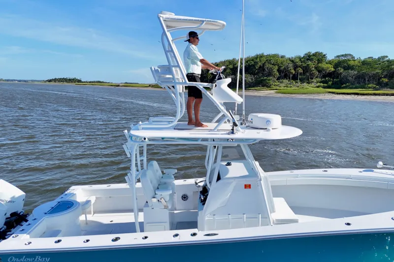  Yacht Photos Pics 2021 Onslow Bay 33 Tournament boat cruising near a scenic shoreline.