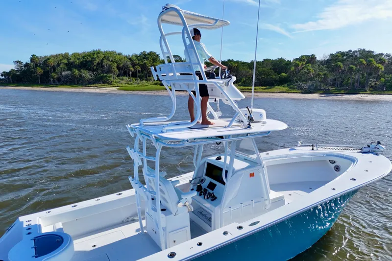  Yacht Photos Pics 2021 Onslow Bay 33 Tournament boat cruising near lush shoreline.