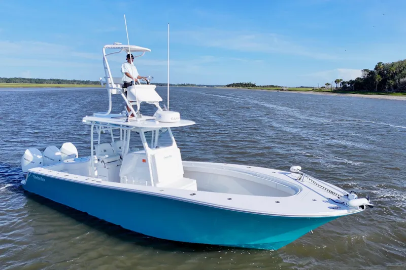  Yacht Photos Pics 2021 Onslow Bay 33 Tournament boat cruising on a sunny day with a person at the helm.