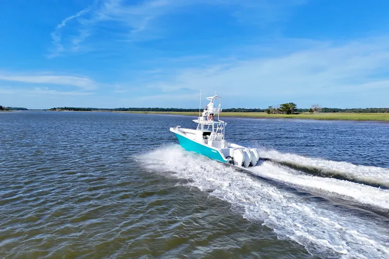  Yacht Photos Pics 2021 Onslow Bay 33 Tournament boat cruising on open water under clear blue sky.