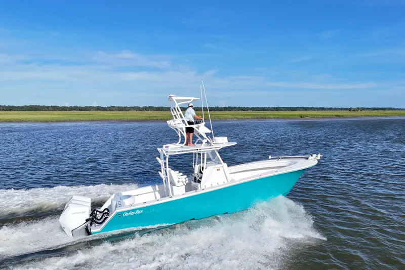  Yacht Photos Pics 2021 Onslow Bay 33 Tournament boat cruising on a scenic waterway under clear blue skies.