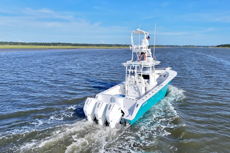  Yacht Photos Pics 2021 Onslow Bay 33 Tournament boat cruising on open water, featuring triple outboard engines.
