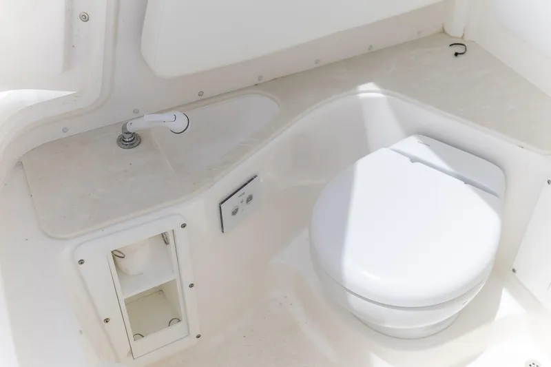  Yacht Photos Pics 2023 Edgewater 262CC boat interior with compact marine toilet and sink.