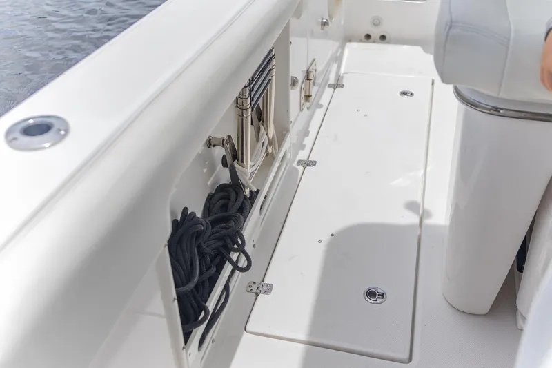  Yacht Photos Pics 2023 Edgewater 262CC boat interior with storage compartment and coiled rope.