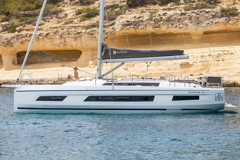  Yacht Photos Pics 2025 Dufour 41 yacht anchored near rocky coastline.