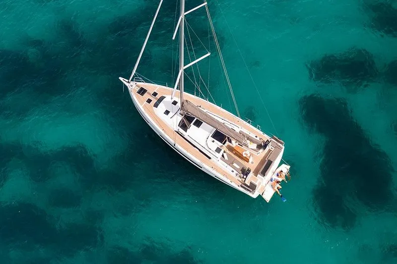  Yacht Photos Pics Aerial view of 2025 Dufour 41 sailboat on clear turquoise water.