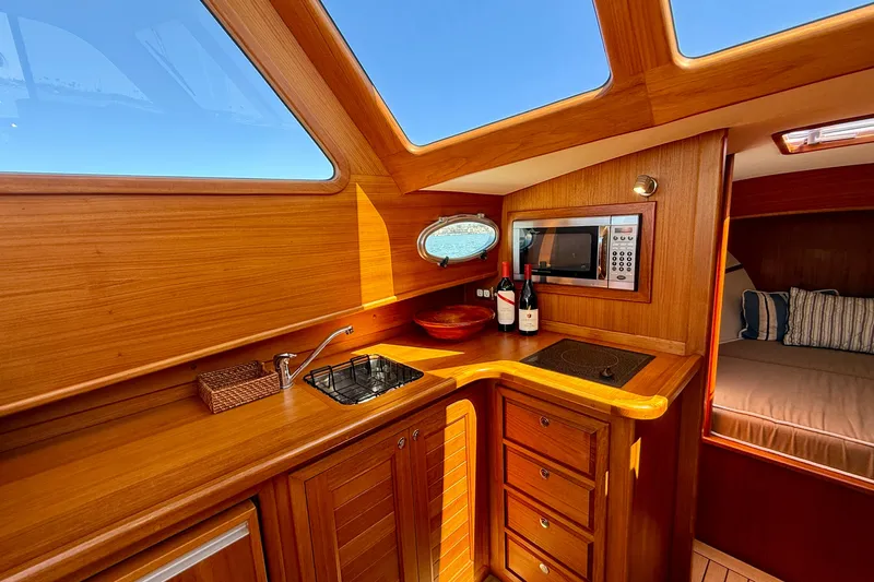 Picnic Yacht Photos Pics Luxurious wooden interior of 2002 Palm Beach Motor Yachts Avalon 38, featuring kitchenette and cozy cabin.