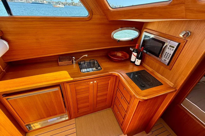Picnic Yacht Photos Pics Luxurious wooden interior of 2002 Palm Beach Motor Yachts Avalon 38 galley with modern amenities.