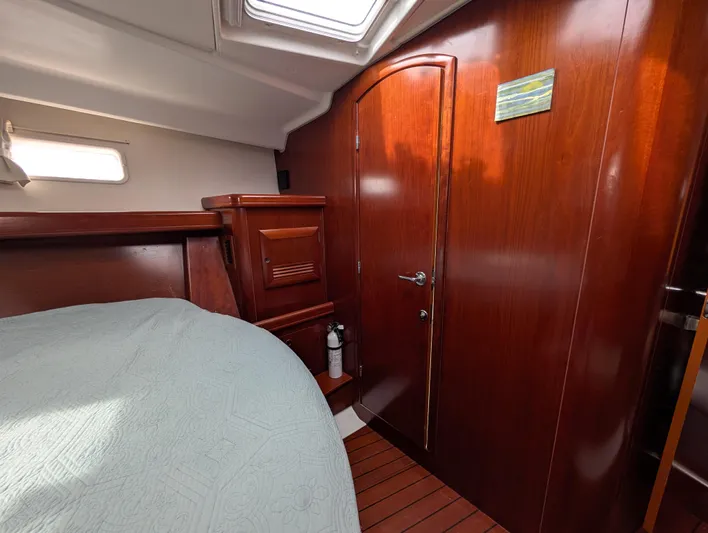 Seastar Yacht Photos Pics Interior cabin of 2003 Beneteau Oceanis 473 yacht with wooden finish and bed.