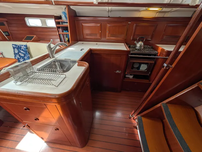 Seastar Yacht Photos Pics Interior of 2003 Beneteau Oceanis 473 yacht kitchen with wooden cabinetry and modern appliances.