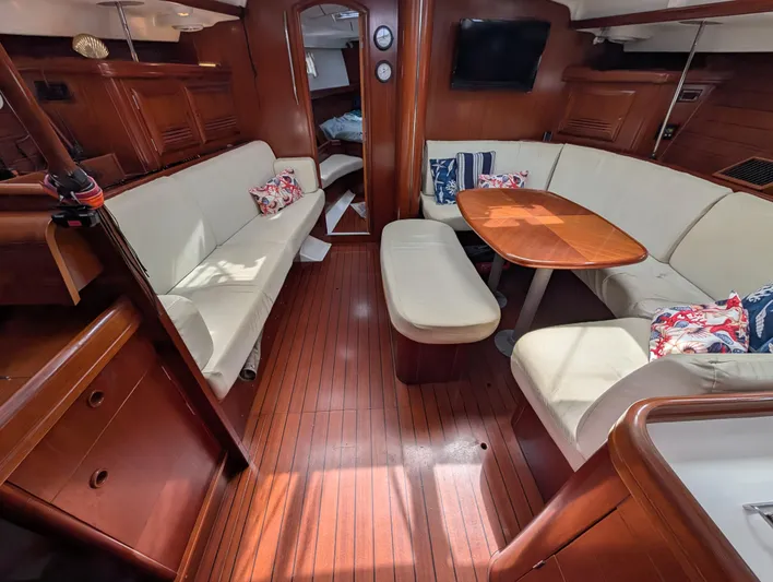 Seastar Yacht Photos Pics Luxurious interior of 2003 Beneteau Oceanis 473 sailboat with elegant wood finish and cozy seating.